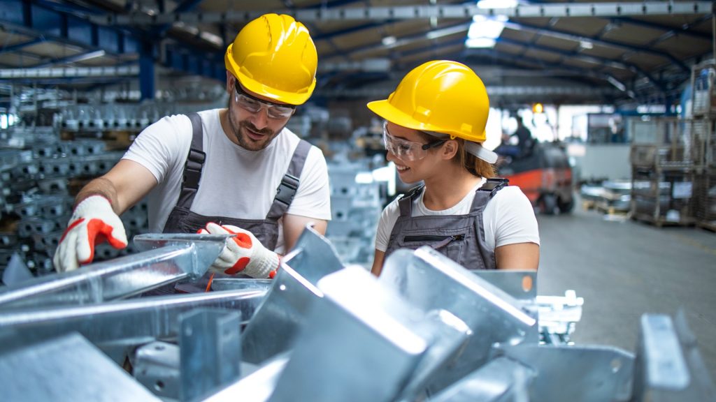 Factory workers checking the quality of industrial metal parts